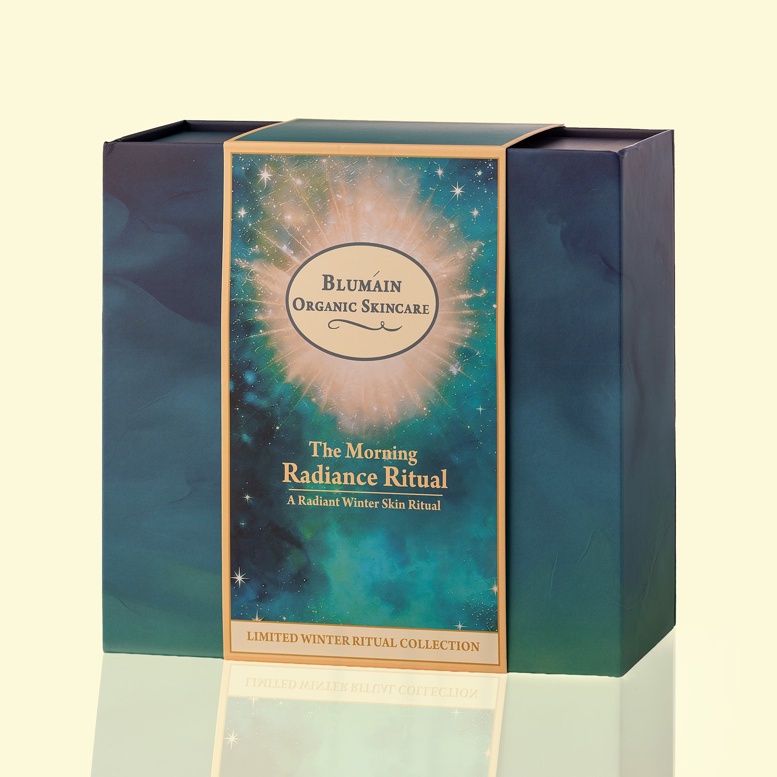 A rectangular skincare product box for Blumain Organic Skincare, titled 'The Morning Radiance Ritual', featuring a cosmic teal and gold design on a light cream background.